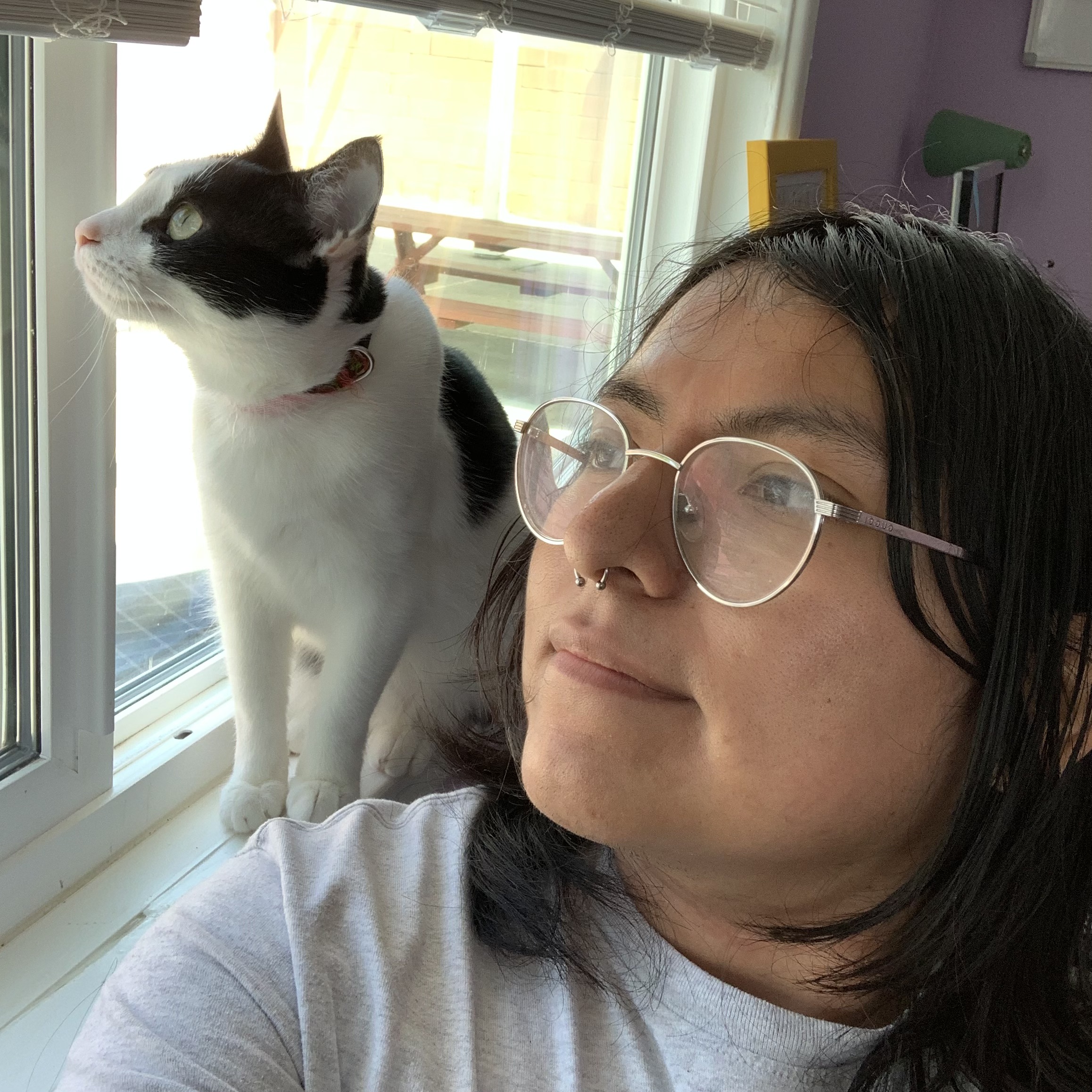 a portrait of teo with oreo, a cat, on their shoulder